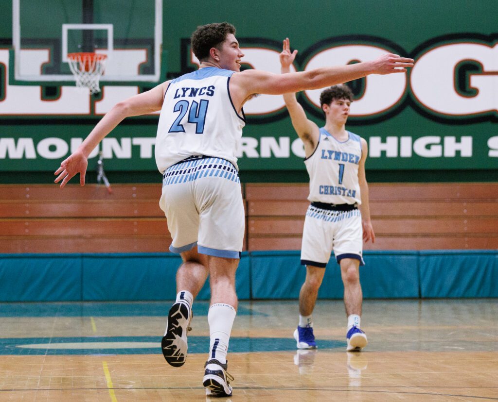 Lynden Christian's Andrew Hommes and Tyler Sipma, right, congratulate teammate Griffin Dykstra.