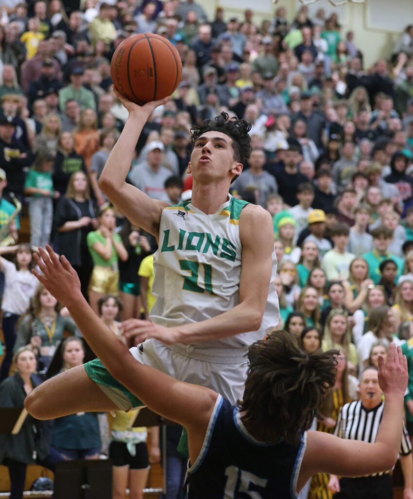 Lynden's Anthony Canales goes up for a bucket over Lynden Christian's Lane Dykstra who is shoved away from his jump.