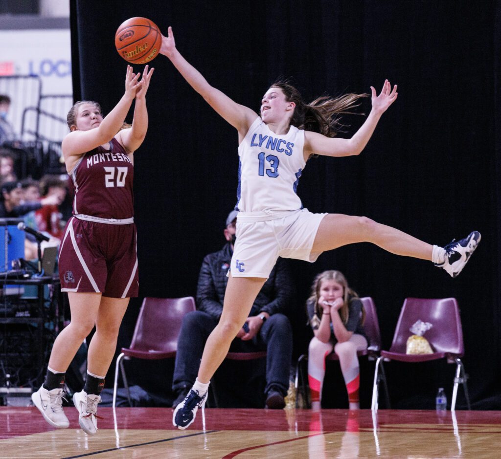 Lynden Christian’s Grace Hintz leaps to steal the ball from Montesano’s Jordan Karr attempting to make a shot for the basket.