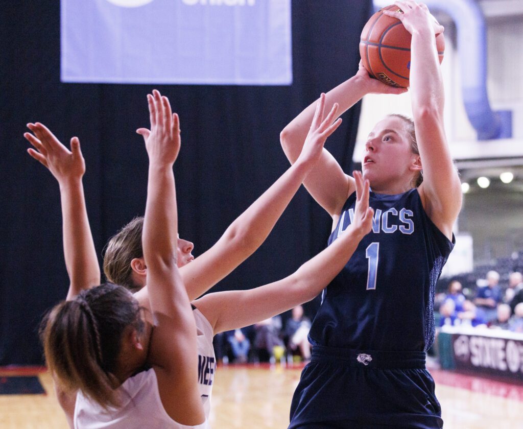 Lynden Christian’s Libby Stump shoots a basket over two Pioneer defenders.