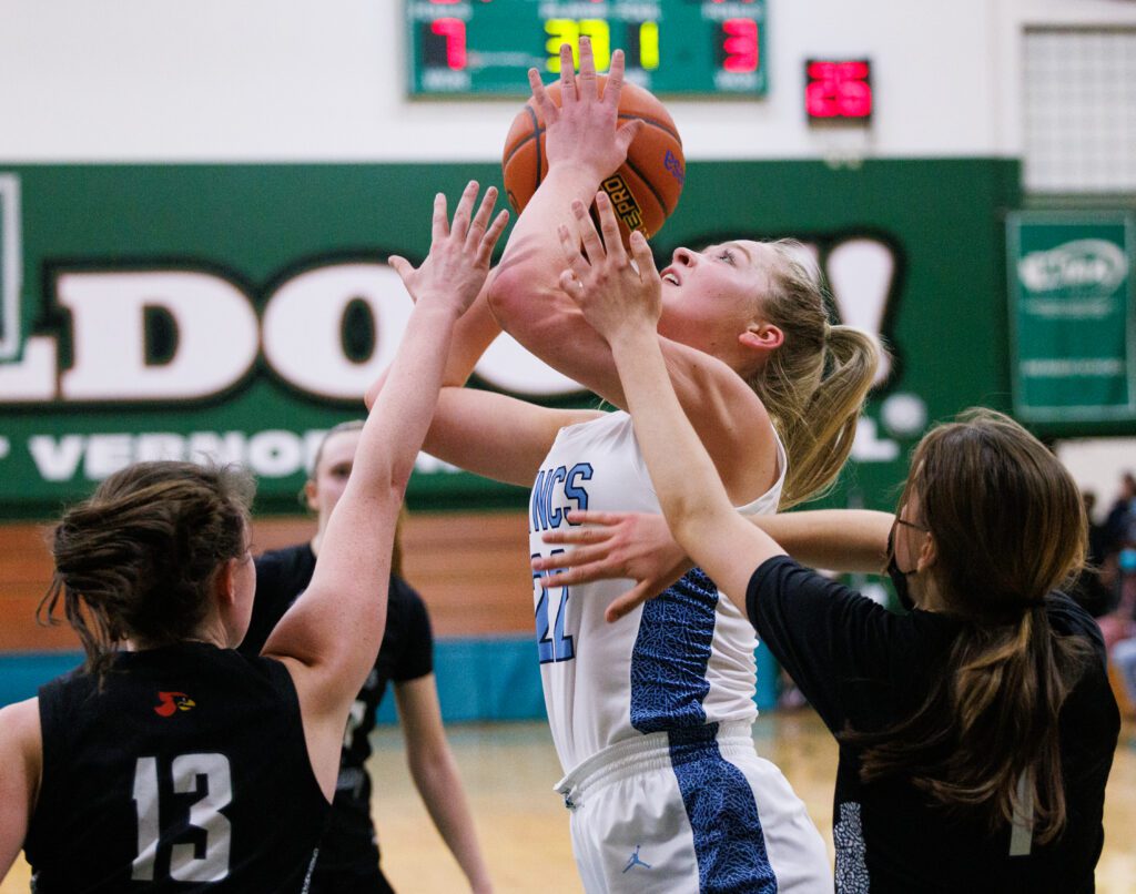 Lynden Christian’s Reganne Arnold goes for a shot as hands from defenders reach for the ball.