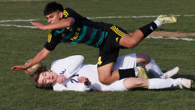 Lynden's Victor Huaracha falls on Lynden Christian's James Creydt as they collide trying to take control of the ball.