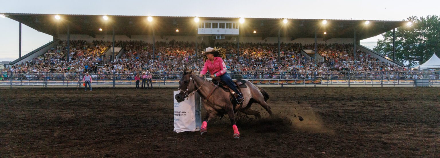 Aimee Henderson of Everson turns around a barrel while on top of a horse.