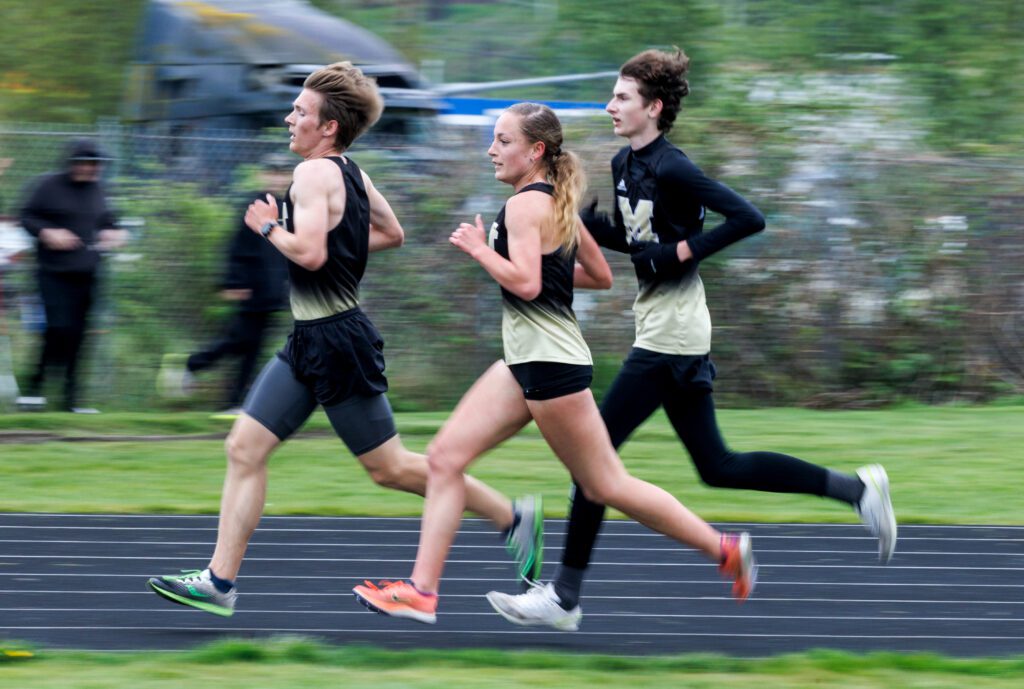 Meridian’s Kayla Aalpoel runs with her male teammates in the 3200-meter run.