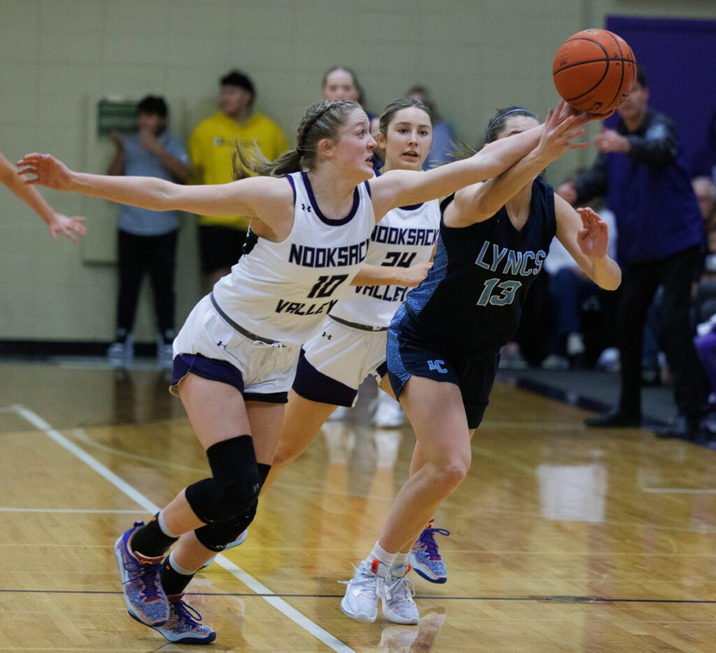 Nooksack Valley’s Lainey Kimball knocks the ball away from Lynden Christian’s Grace Hintz hands as another defender looks for an opening from behind them.