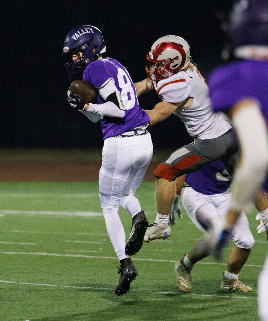 Nooksack Valley's Bennett DeLange leaps and intercepts a pass intended for Riverside's Tyler Lenz.