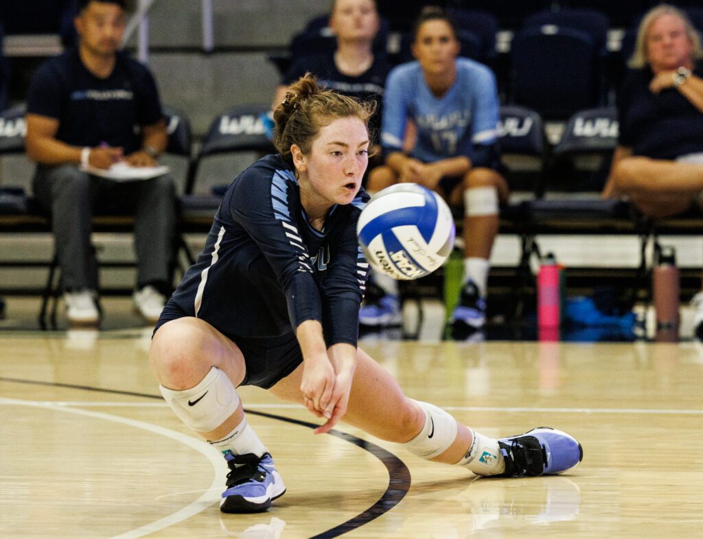 Western Washington University's defensive specialist/libero Kasey Woodruff squats low to bump the ball.