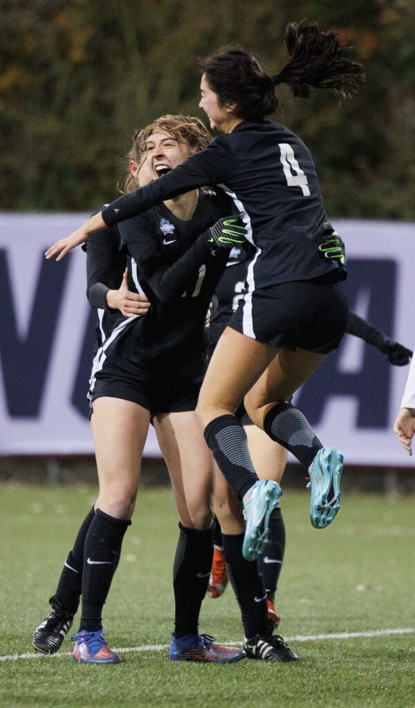 Western Washington University’s Sophie Bearden Croft, center, is all smiles as teammates rush to hug her with one jumping into her arms.