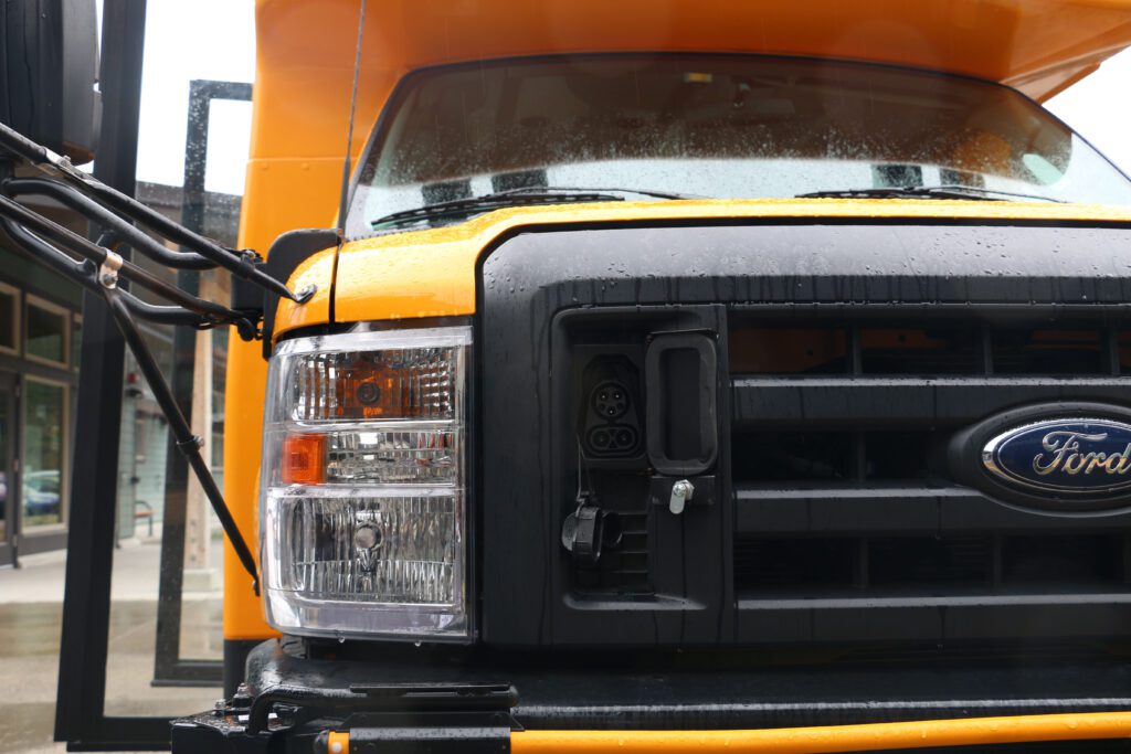 The front of the new electric bus is wet from the rain.