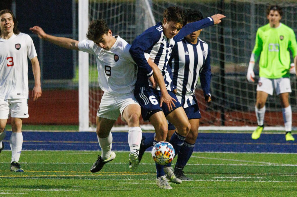 Bellingham's Dillon Strain and Squalicum's Cole Elston battle for the ball as they shove each other.