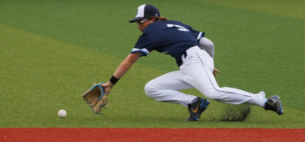 Alex Fernandes makes a stop on a grounder as he dives forward for the ball.