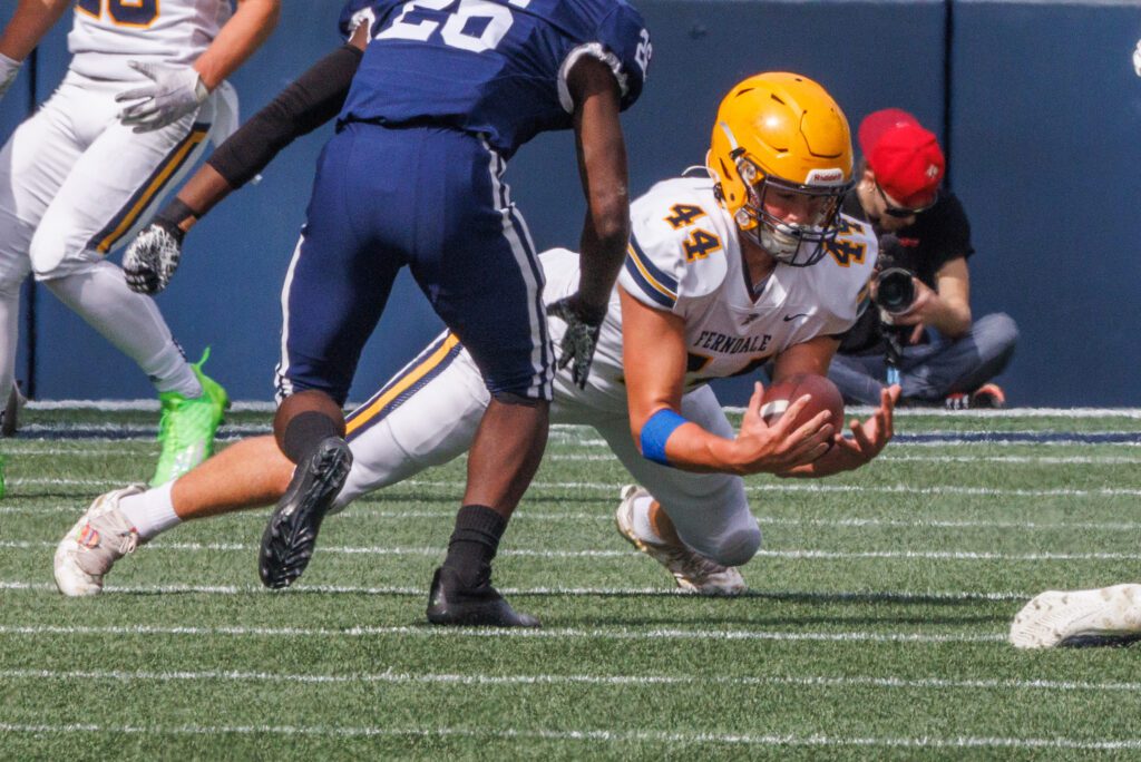 Ferndale's Jordan Mason grabs a fumbled ball as a defender rushes to him.