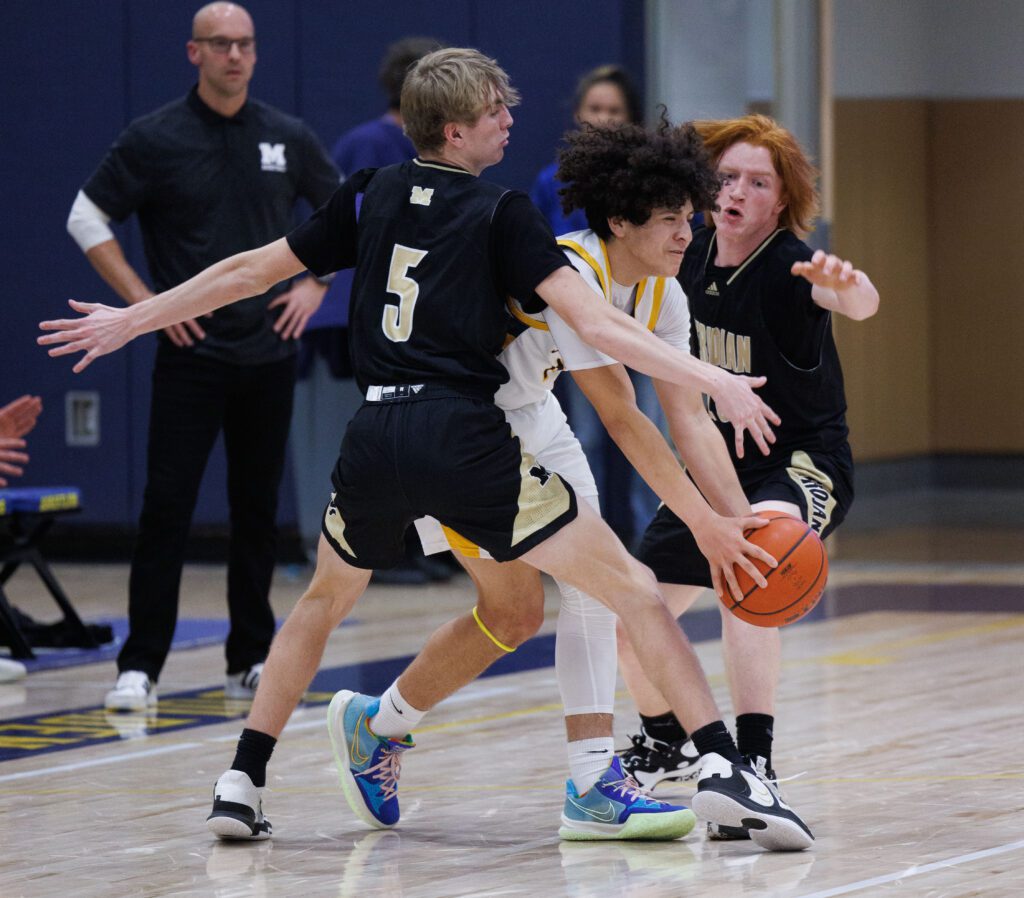 Meridian's Jaeger Fyfe and Landon James pressure Ferndale's Bishop Ootsey as he tries to squeeze past the defense.