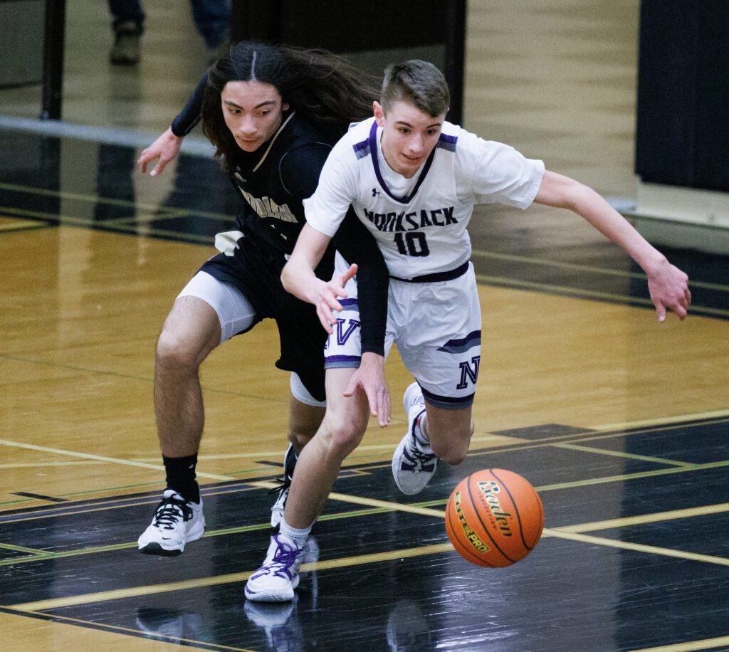 Meridian's Taran Burks and Nooksack Valley's Caden Heutink turn to reach for the loose ball.