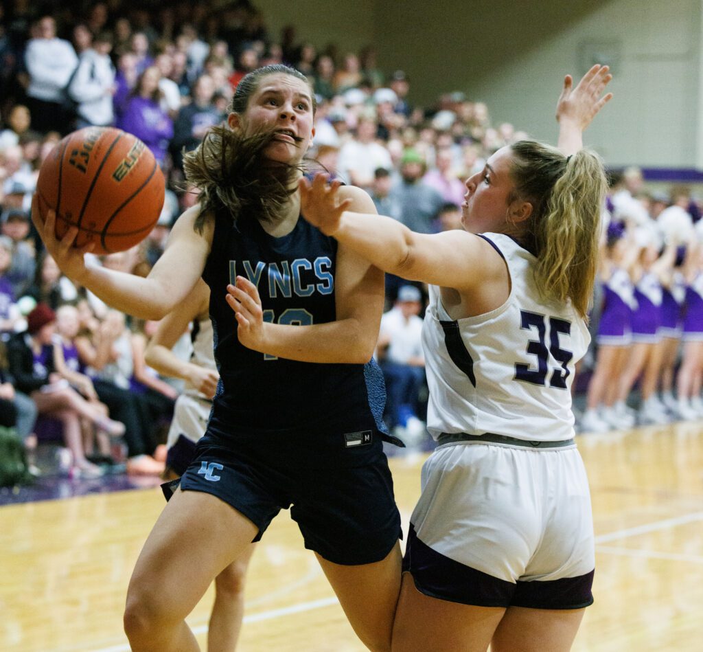 Lynden Christian’s Grace Hintz looks for the basket as she drives past Nooksack Valley’s Ella Perry's defense.