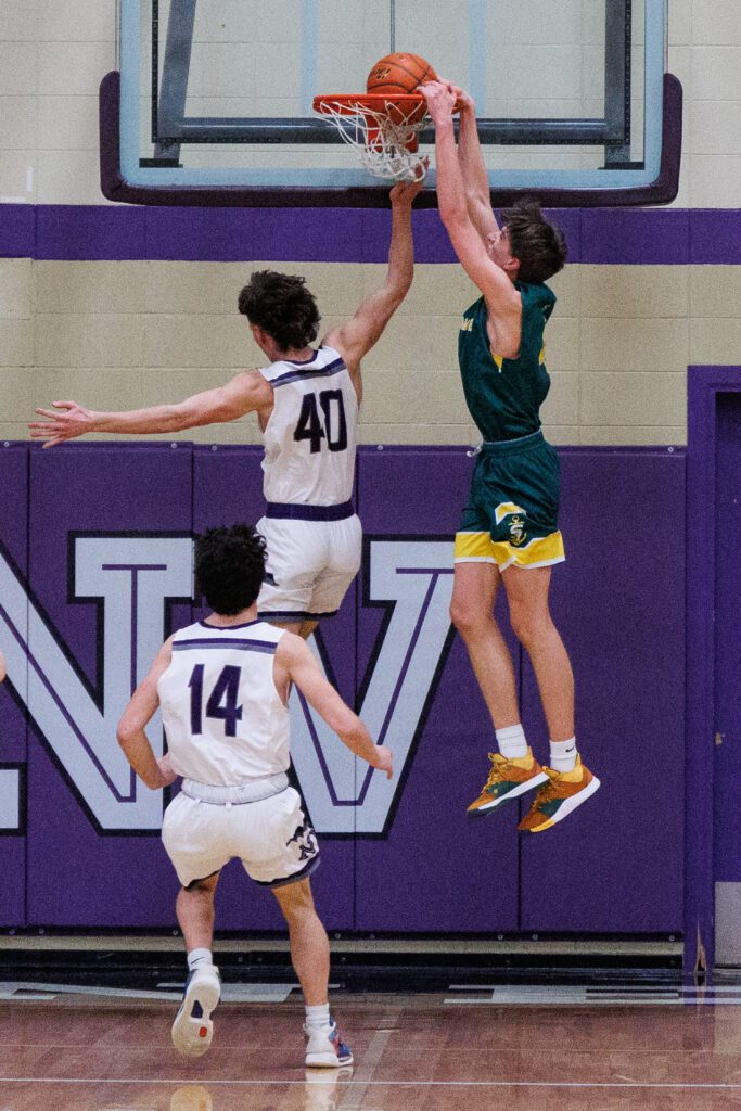 Sehome's Grey Garrison slam dunks over Nooksack Valley's Joey Brown.