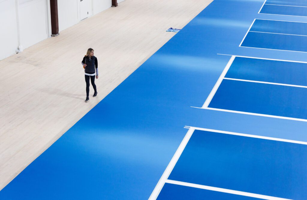 Diana Stroyls looks over the bright blue courts at Armory Pickleball.