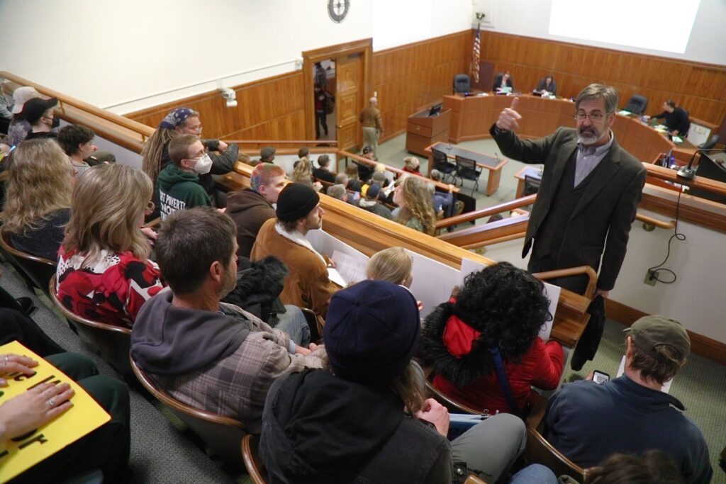 Bellingham City Council President Michael Lilliquist speaks to protesters about rules regarding the display of signs brought into the meeting.