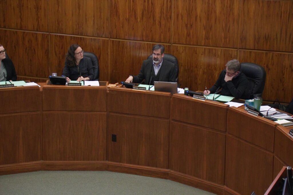 The Bellingham City Council debates as one member writes.