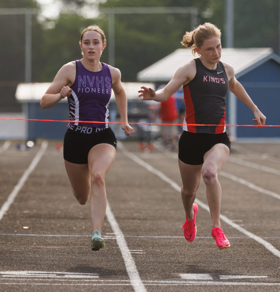 Nooksack Valley's Kate Desilets is edged out at the finish line by King’s Regan Parnell as they run side by side with their eyes on the finish line.