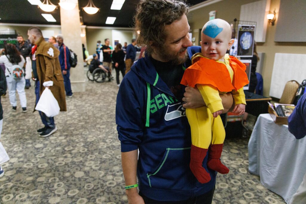 Joe Fraser dresses up his son, Finley, 9 months old, as Aang the Airbender with blue paint on the baby's bald head.