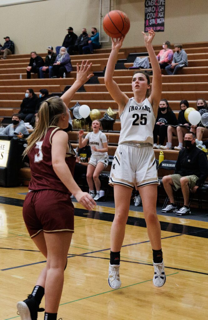 Meridian's Ellie DeWaard jumps to take a shot as a defender raises an arm to block.