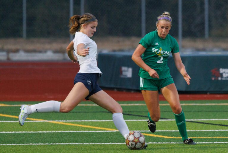 Squalicum's Elise Montgomery, left, takes a shot at the goal as Sehome's Evelyn Sherwood puts pressure from the side.