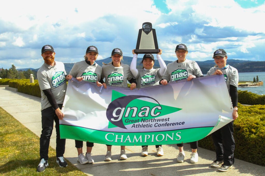 The Western women's golf team poses with the trophy and banner.