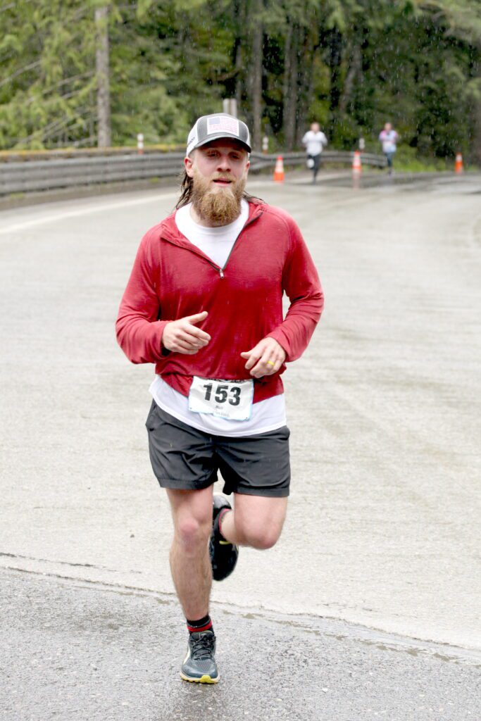 Cory Brunhaver jogs ahead of other runners in the rain.