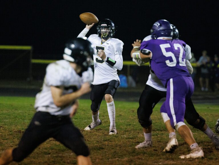 Meridian quarterback Jaeger Fyfe looks to throw to Josh Elmer as another one other teammate tries to block an opposing team's player.