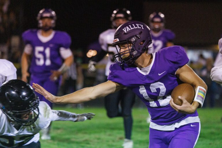 Nooksack Valley quarterback Joseph Brown reaches out to stiff arm a Meridian defender.