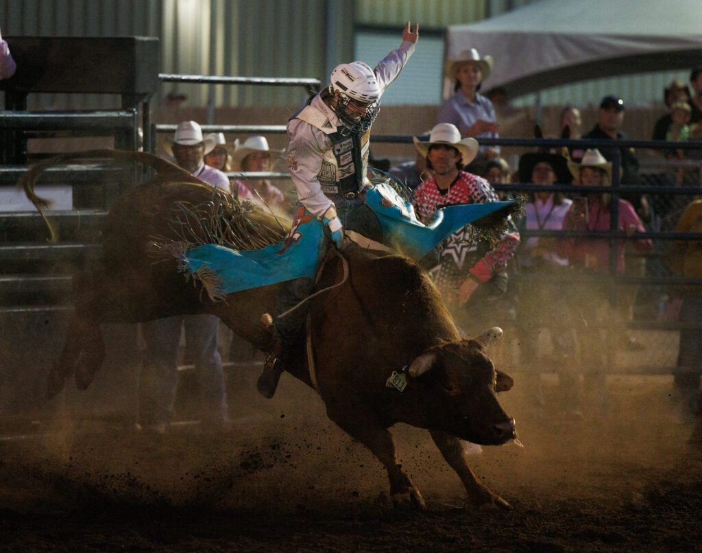 Garrett Smith of Rexburg, Idaho, holds on to the bull with a football helmet on.