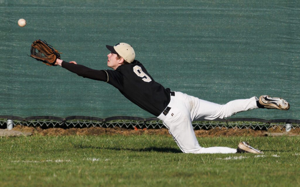 Meridian’s Tyson Timmer dives for the ball with his arms reached out.