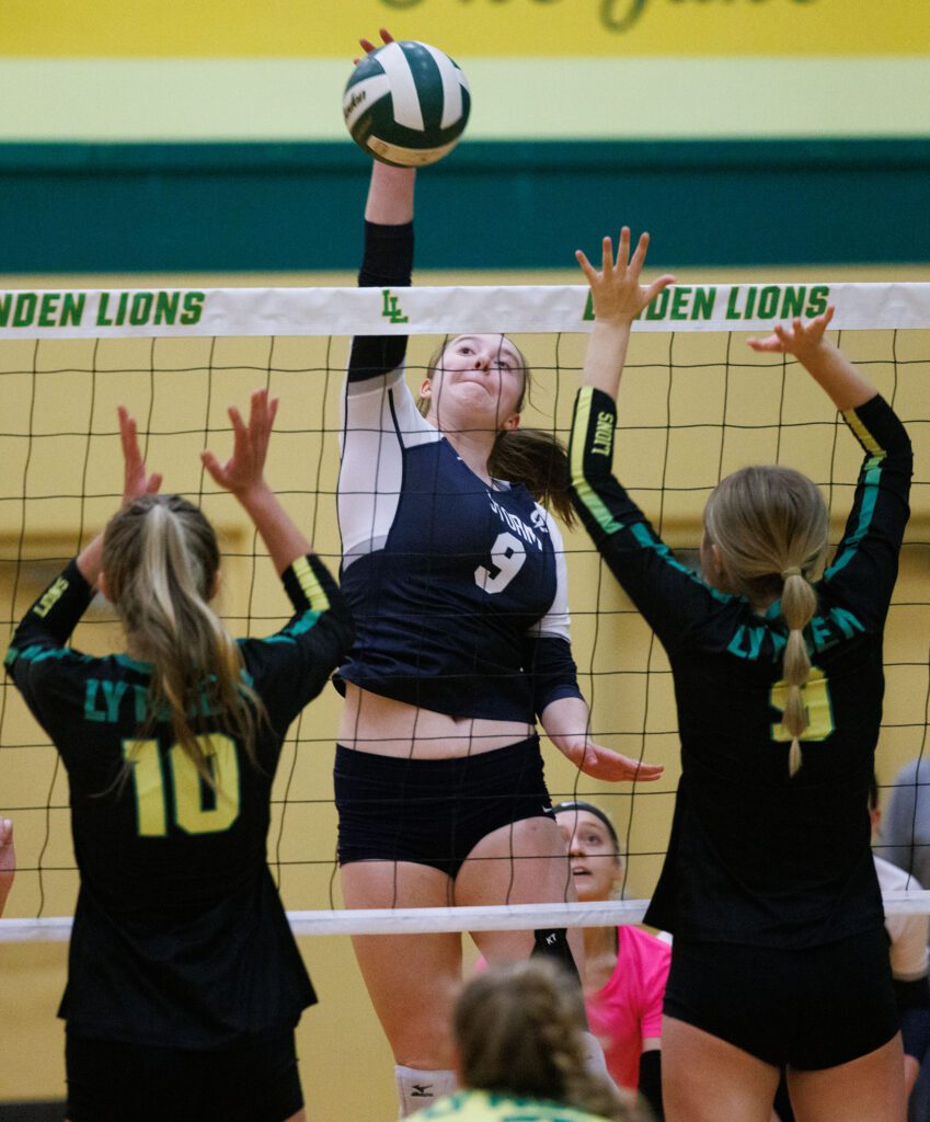 Squalicum's Olivia Swayne slams the ball over the net as defenders get ready to block the shot.