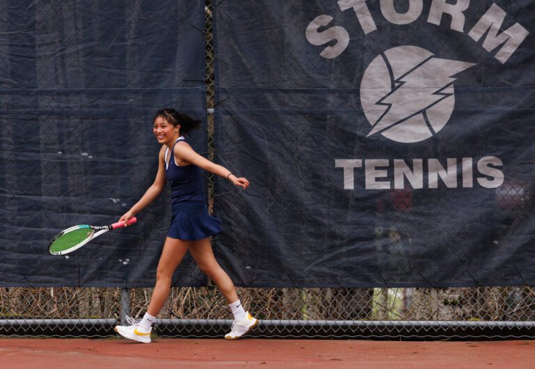 Squalicum’s Bernadine Salvatierra reacts to a blind return shot she made while running toward the fence against Bellingham's Ellie Wolverton in a singles match on March 22.