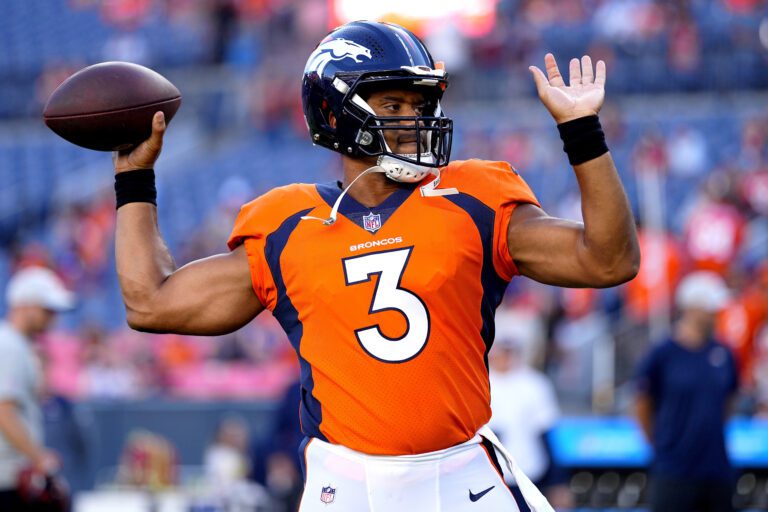 Denver Broncos quarterback Russell Wilson (3) raises both arms with the ball in one hand.