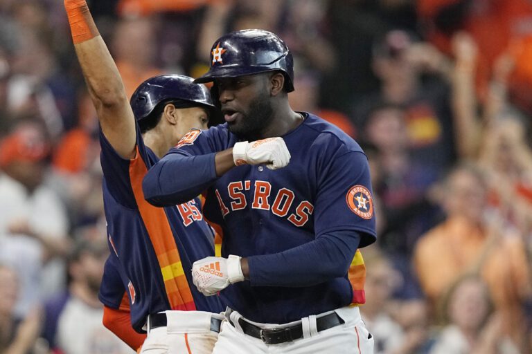 Houston Astros' Yordan Alvarez, right, celebrates his two-run home run with hand gestures.