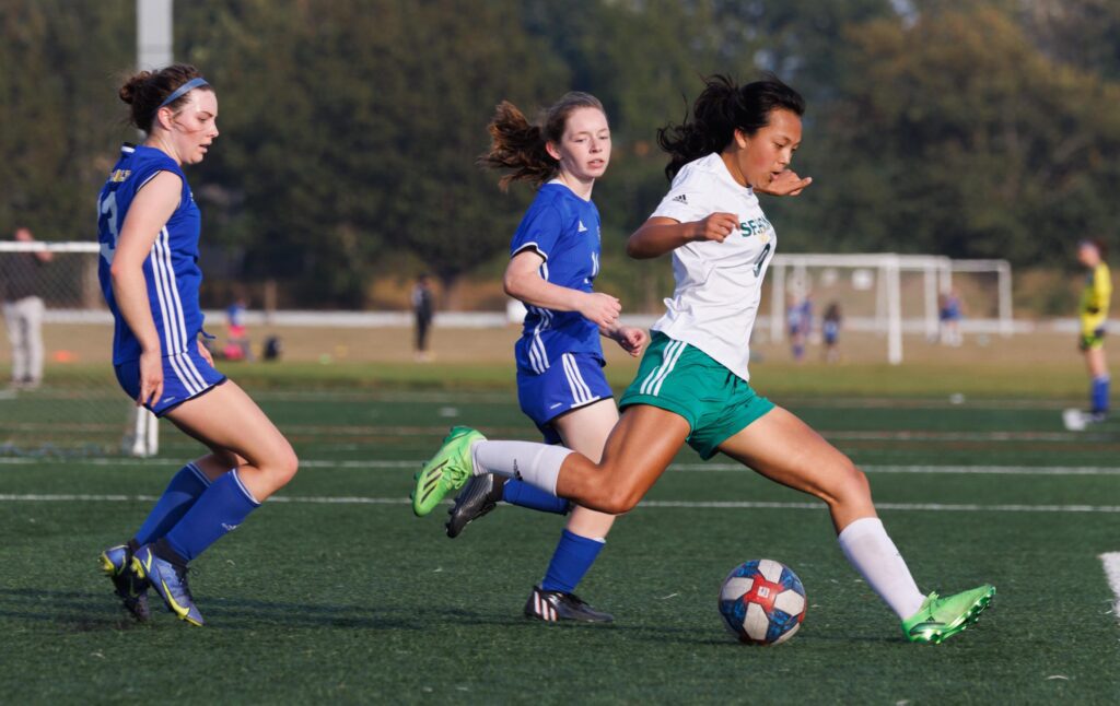 Evelyn Keay pulls back her leg to kick the ball as defenders maintain their pressure.