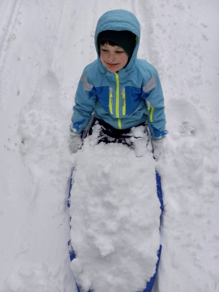 Sweeney's child ends the sled down with excess snow piling up in their sled.