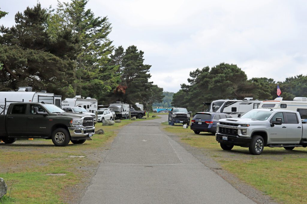 RVs and other vehicles congregate on the side of the paved road.