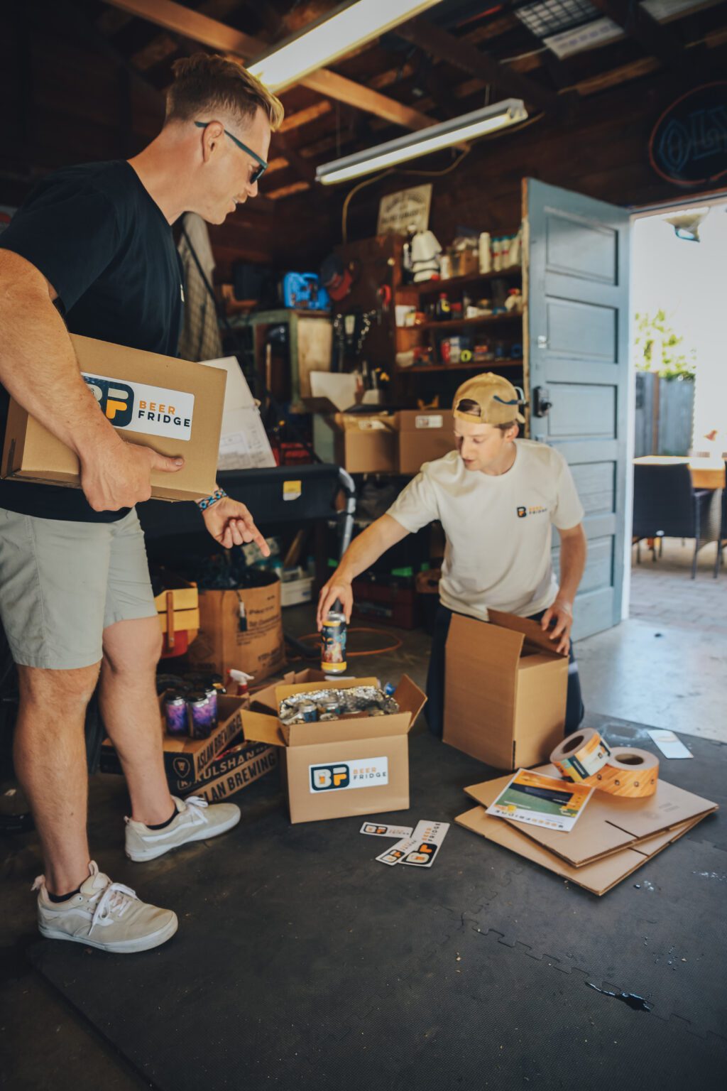 Beer Fridge founders Travis Kane (left) and Jake Bassett fill curated craft beer boxes.