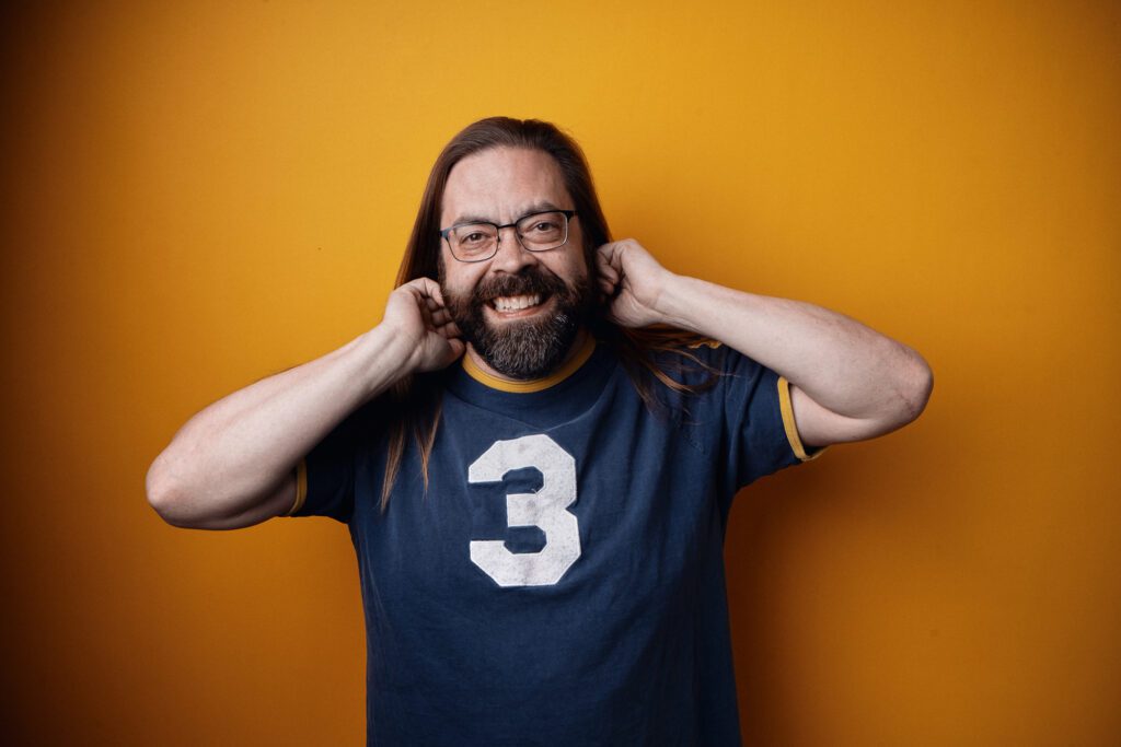 Gabriel Rutledge fixes his hair as he smiles.