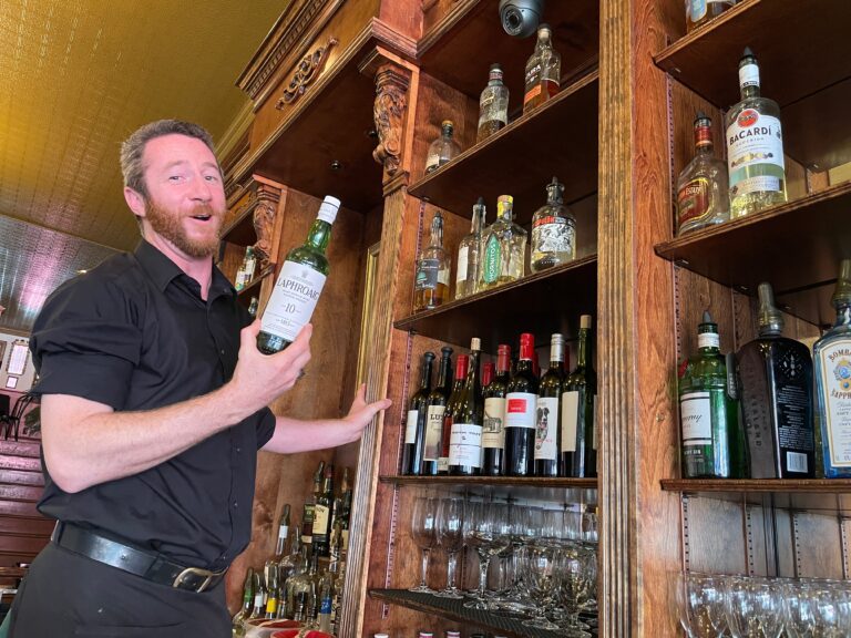 At Skylark's Hidden Cafe, John Drum reaches for a bottled drink from the high shelves.