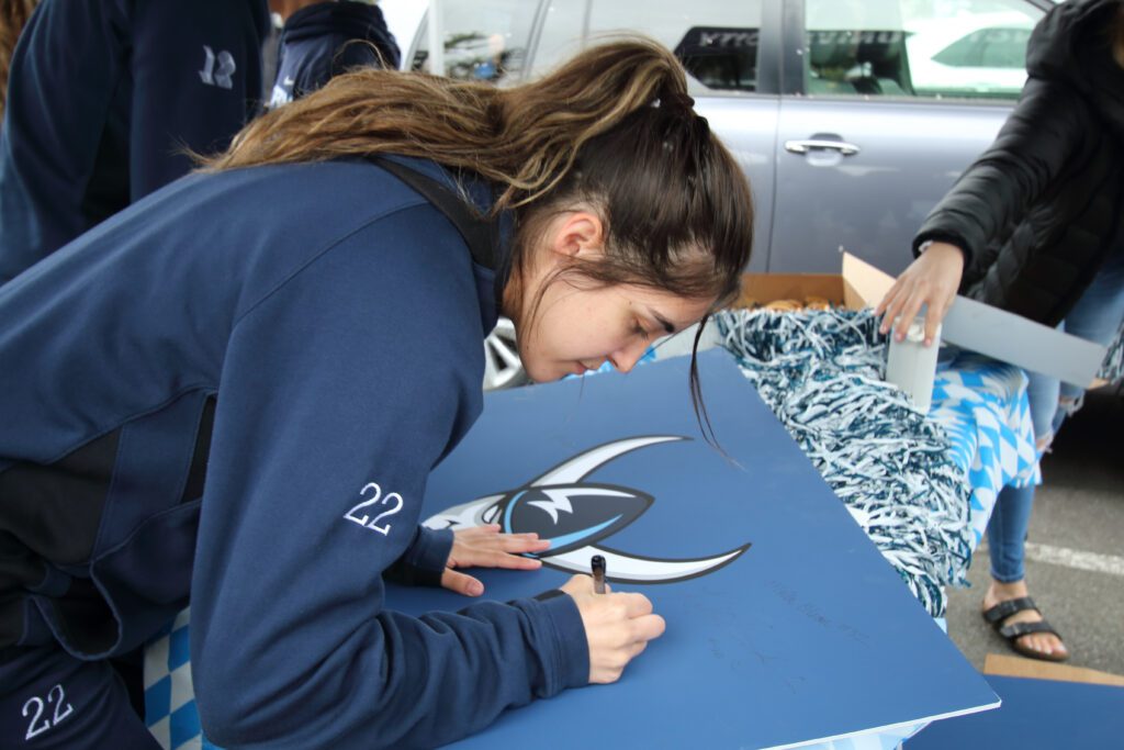 WWU senior guard Gracie Castaneda signs a blue Viking placard.