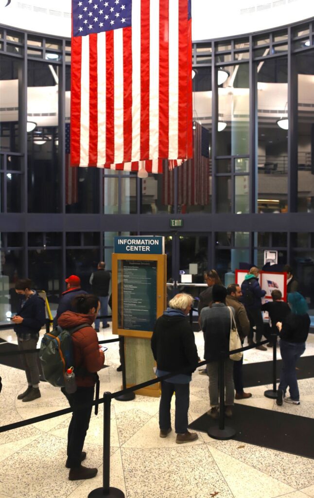 An American flag hangs above voters waiting in queue at the Whatcom County Courthouse.