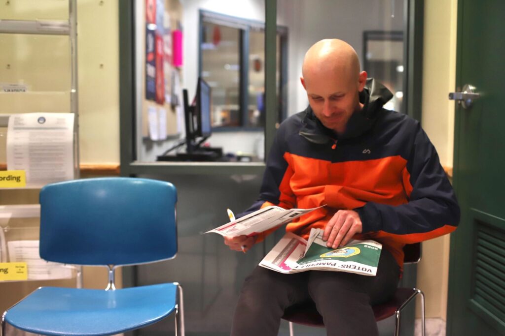 Alastair Fowler fills out his ballot on his legs at the courthouse.