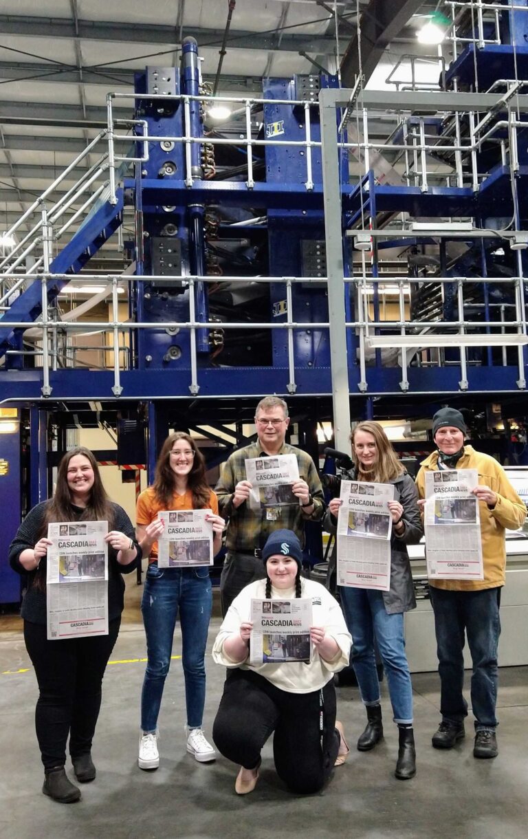 CDN staffers hold up the first copy of the Cascadia Daily News at Skagit Publishing on March 1.