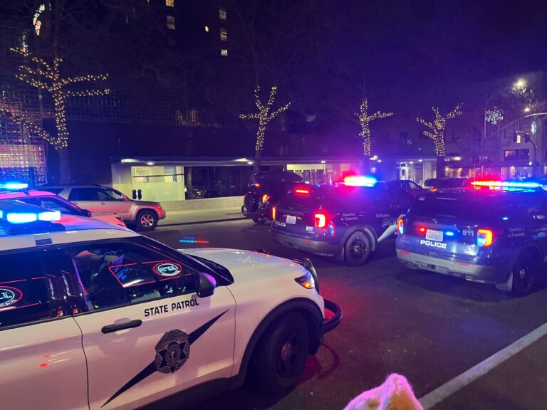 Bellingham Police vehicles flash lights as they block the road.