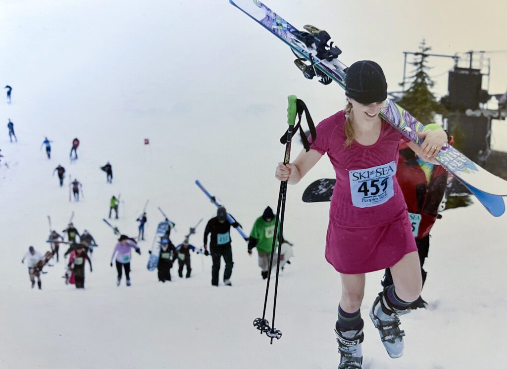 Karin Ayling of The Real Housewives of Whatcom County carries her skis up the slope leaving behind a trail of skiers making their way up the slope.