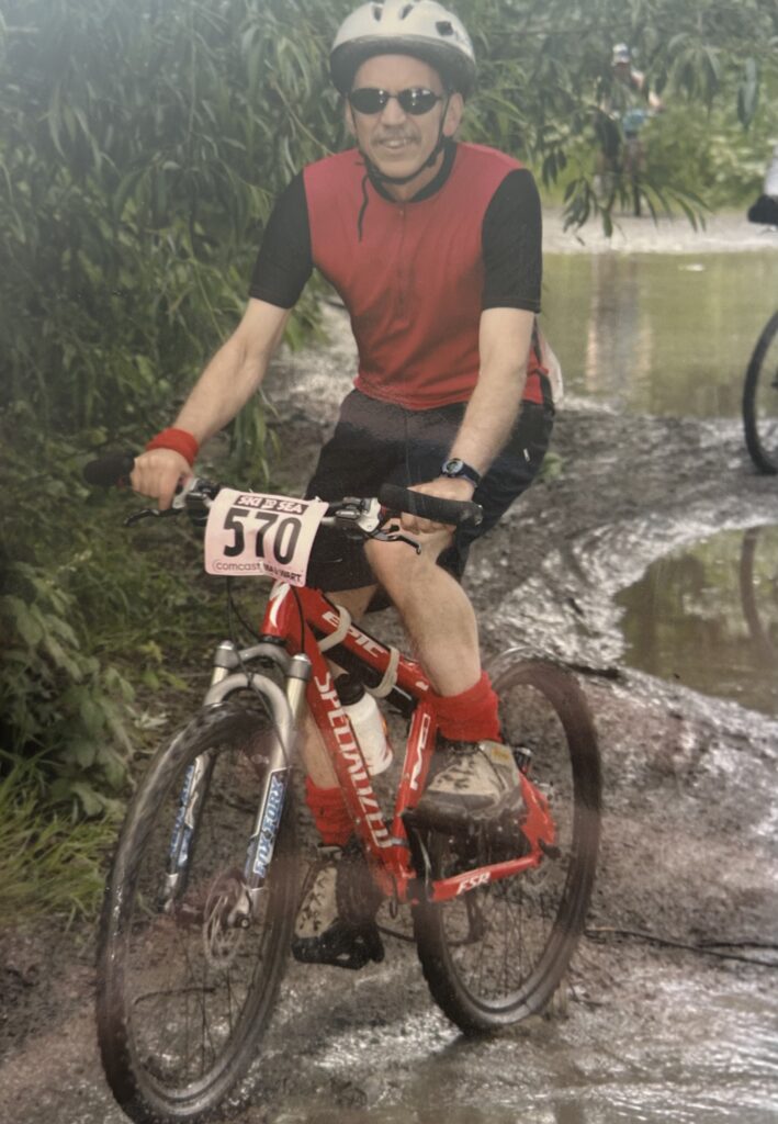 An old photo of Clare Fogelsong on a bike with the ski to sea sticker on the front.